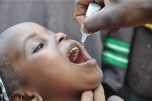 A child receiving polio drops