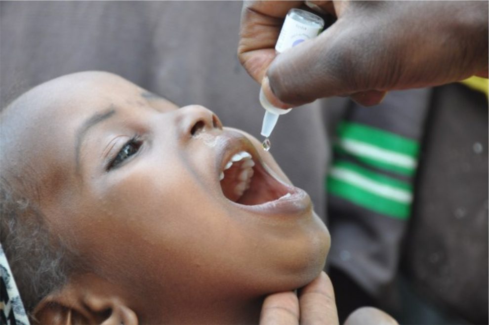 A child receiving polio drops